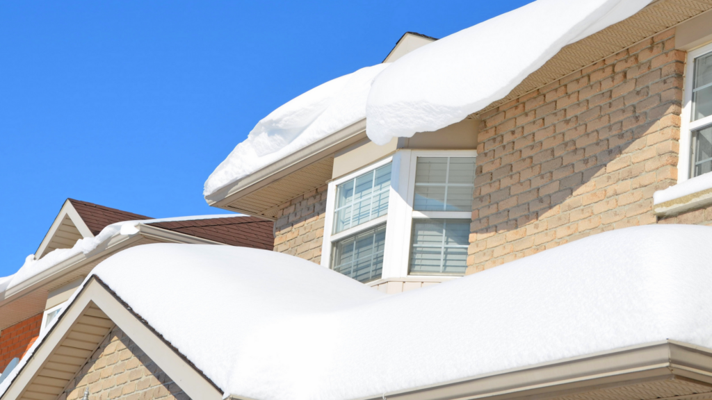 "Heavy snow accumulation on asphalt shingle roof in winter"