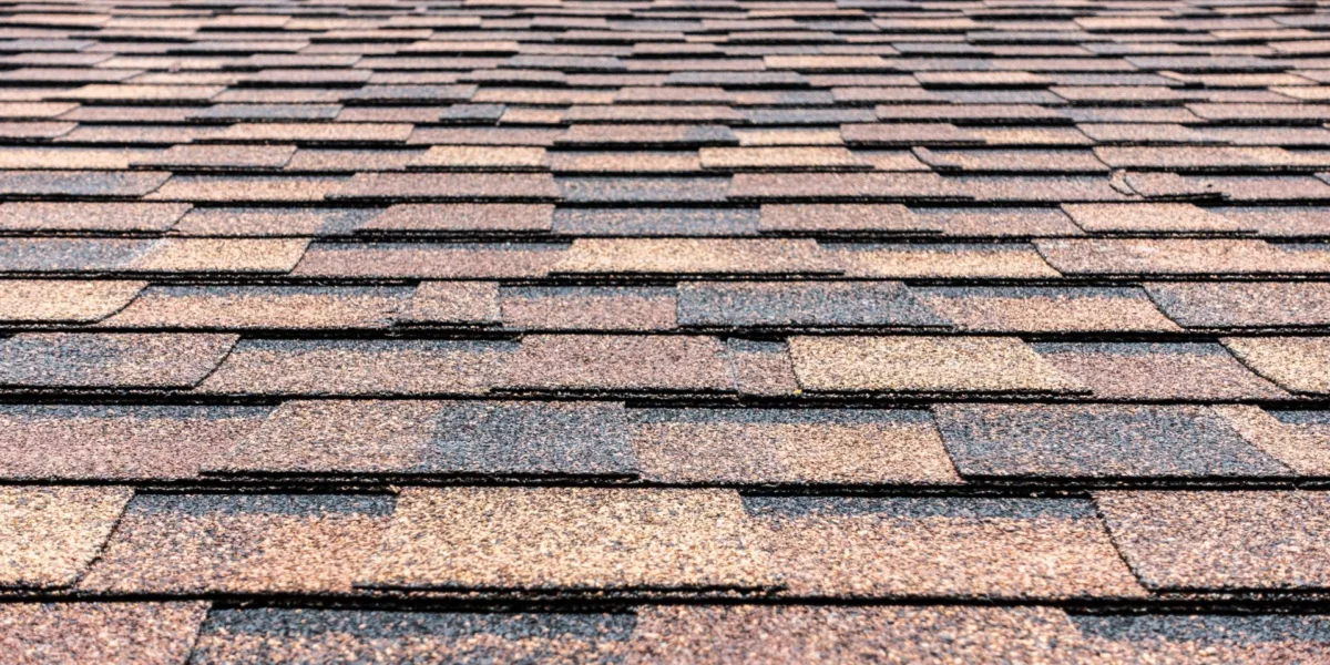 "Close-up of asphalt shingle installation on sloped roof"